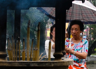 A woman burns incense at Polin Monastery